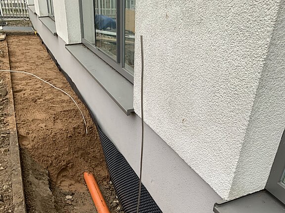 Kabelrohre beim Verfüllen im Graben