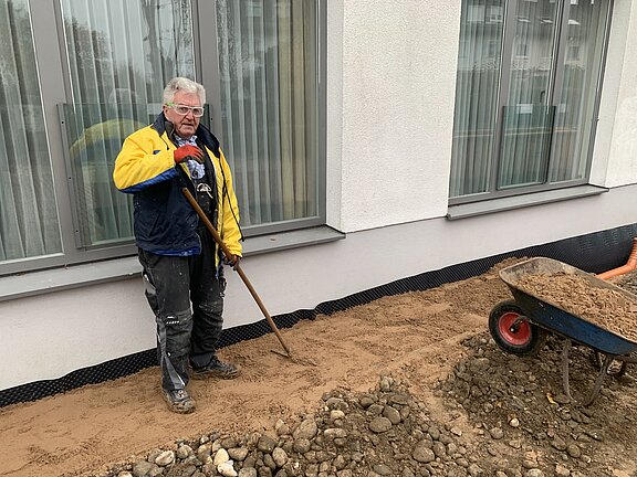 Karl-Heinz Fichtner beim Verfüllen des Grabens mit Sand