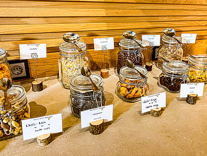 Müsli- und Cerealienstation mit Gläsern und Beschriftung am Frühstücksbuffet