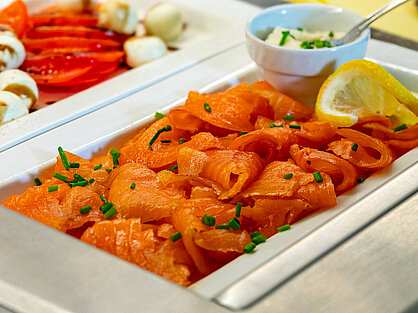Premium Räucherlachs mit Schnittlauch und Zitrone auf dem Frühstücksbuffet