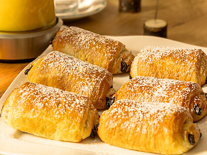 Frisch gebackene Schokobrötchen mit Puderzucker auf dem Frühstücksbuffet